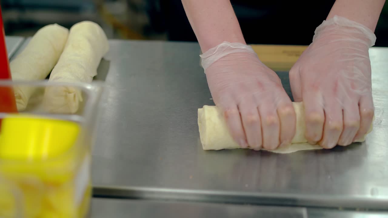 CU Cook rolls the vegetables into the dough for cooking woks
