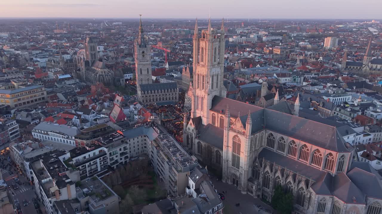 Luce calda pomeridiana sullo skyline di Gand, che mette in risalto edifici pittoreschi e architettura storica in una scena urbana calma e suggestiva.