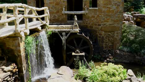 static video of the old mill in little rock arkansas. a waterfall and a water wheel can be seen