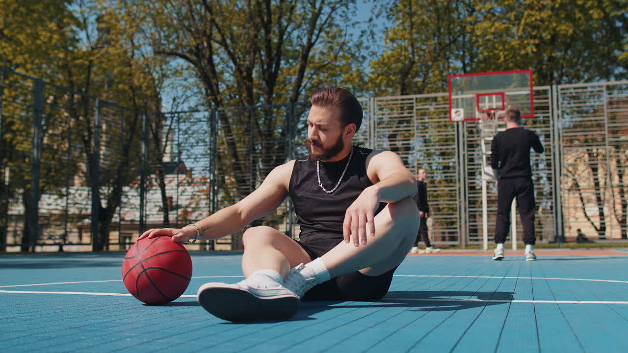 Portrait of tired smiling athletic lebanese man in sportswear relaxing after playing basketball game