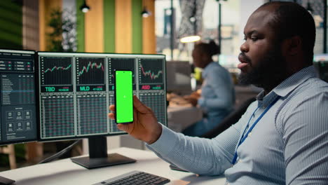 trader in prop firm office attends virtual meeting using green screen phone