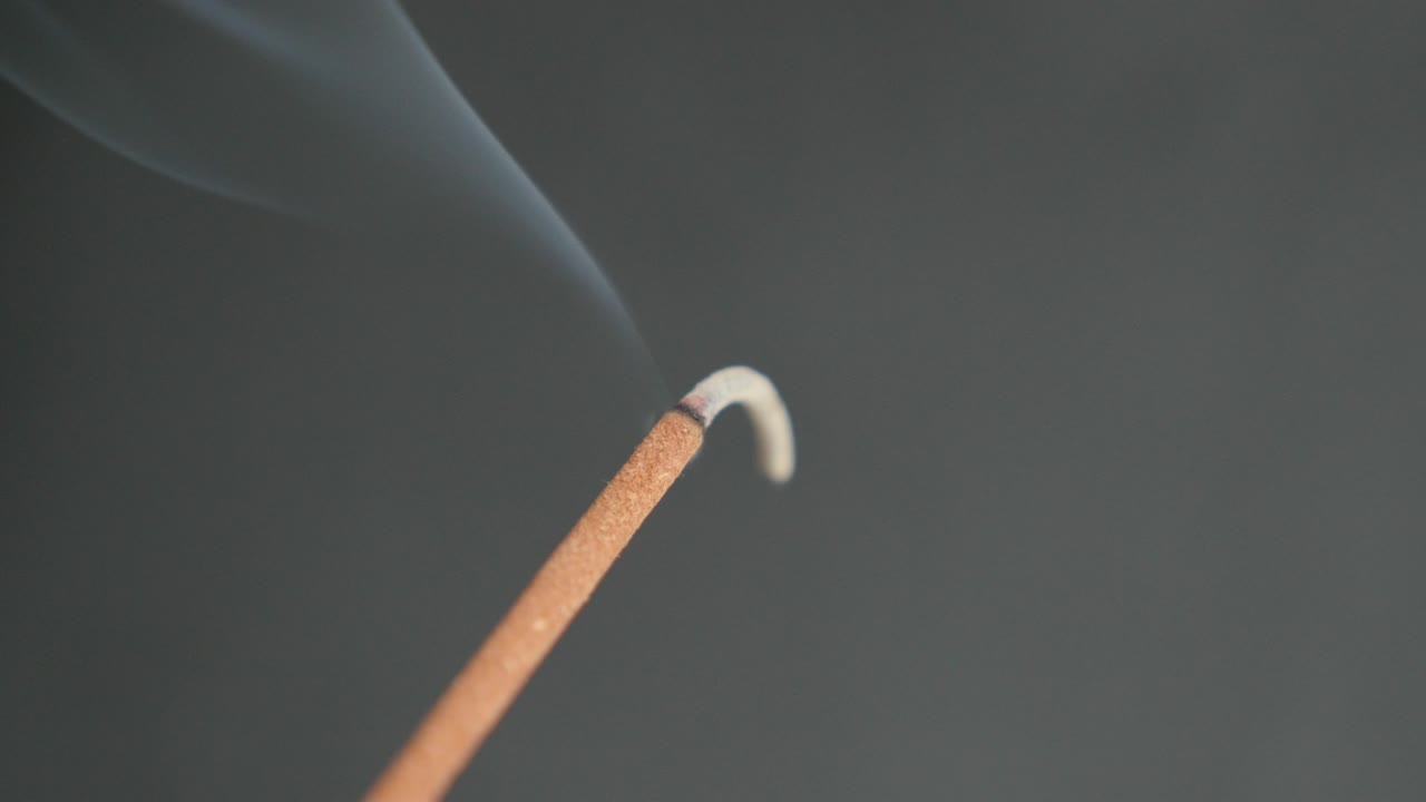 primer plano del humo perfumado que se extiende desde el incienso quemado 4k 2160p 30fps imágenes ultrahd - material biótico aromático que se quema con fines de meditación 3840x2160 video uhd