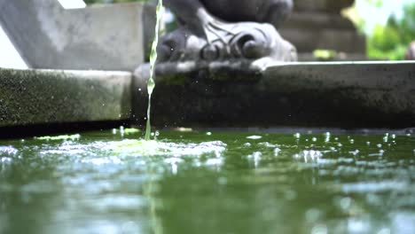 water running in slow motion in the water fountain at a local religious temple in bali