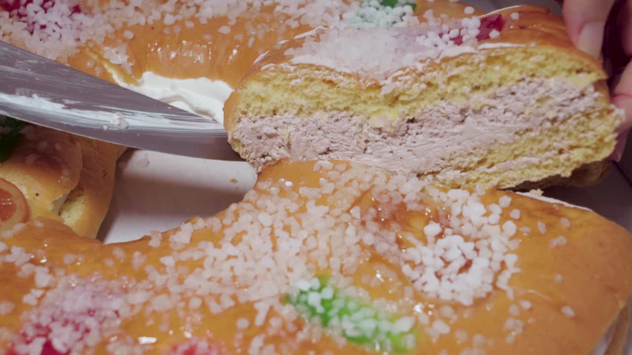 여자는 트러플 크림을 곁들인 로스콘 데 레예스 스페인 크리스마스 페이스트리 조각을 먹습니다