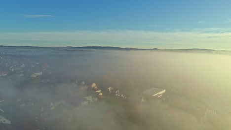 aerial drone shot over beautiful town houses through white clouds in germany at daytime