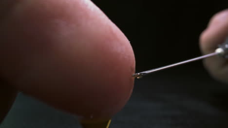 person touches syringe needle with antiviral vaccine