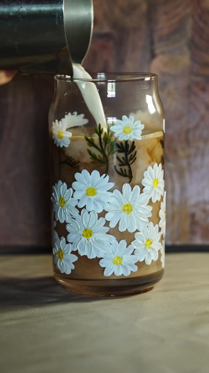 Bevanda al caffè fredda con ghiaccio e consistenza liscia in un ambiente minimale. L'illuminazione soffusa e la presentazione semplice creano filmati lifestyle versatili.