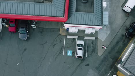 2-2 aerial hold over fastfood drive thru next to a gas station with 8 pumps and 2 outdoor retail ice box storages with an intigrated store within the gas station that selss prepackaged goods donuts