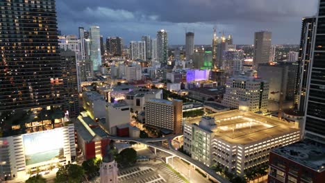 Luftaufnahme-Der-Innenstadt-Von-Miami,-Nachts-Beleuchtet,-Mit-Modernem-Skyline-Wolkenkratzergebäude-Bei-Sonnenuntergang