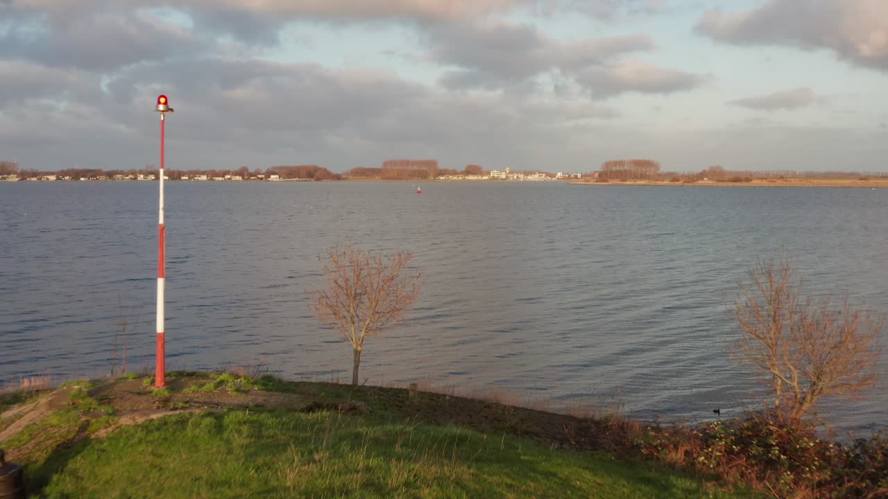 Low drone shot flying over a dyke next to the Canal through Walcheren