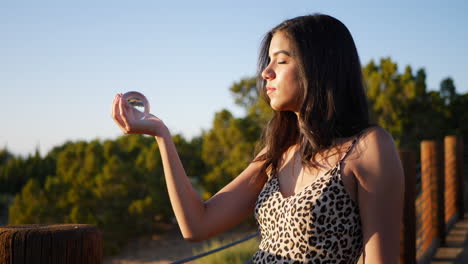 beautiful hispanic woman sorcerer in a fantasy land holding a magic crystal ball casting a spell or enchantment slow motion