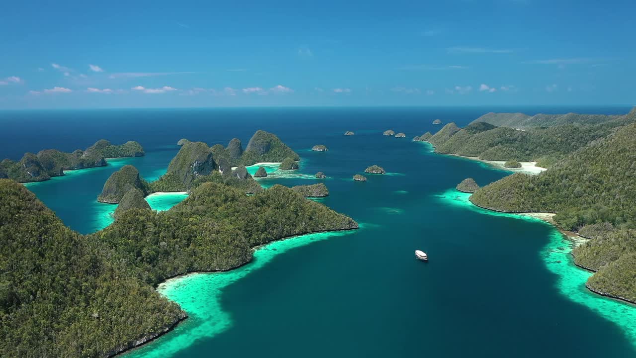 excelente toma aérea de un barco navegando entre las islas wayag, raja ampat, indonesia