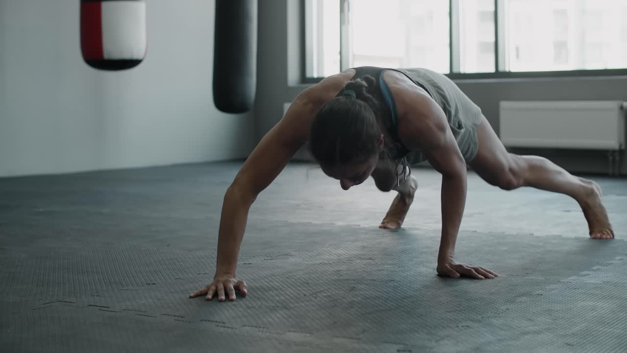 mujer haciendo flexiones en un gimnasio