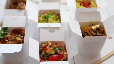 asian take away or delivery food concept  paper boxes placed on white wooden table