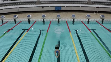 a man jumping on water in a olympian swimming pool