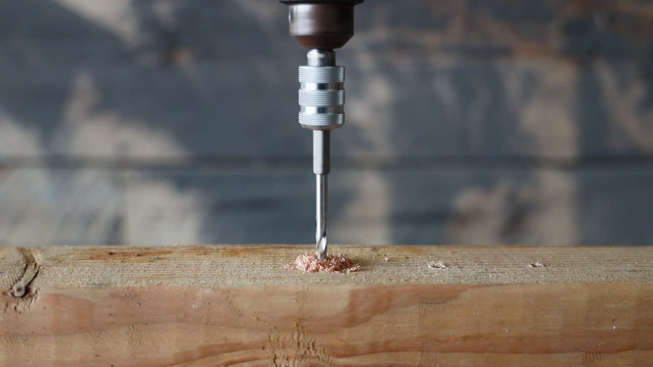 A drill bit drilling a hole into a piece of wood