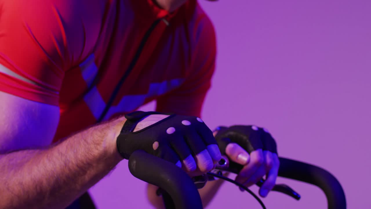 ciclista masculino caucásico con bicicleta sobre iluminación rosa