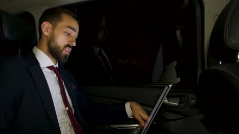 businessman looking over the window of his luxury car at night