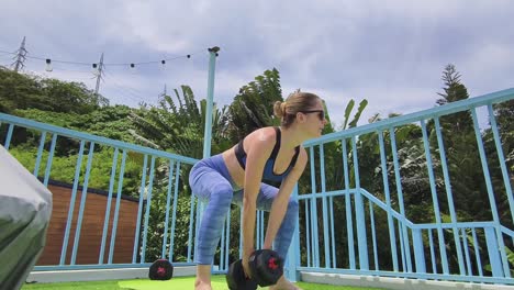 mujer trabajando al aire libre con pesas