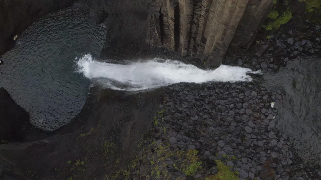 fotografía aérea de arriba hacia abajo de la cascada de litlanesfoss cayendo en el lago durante un día nublado - islandia, europa
