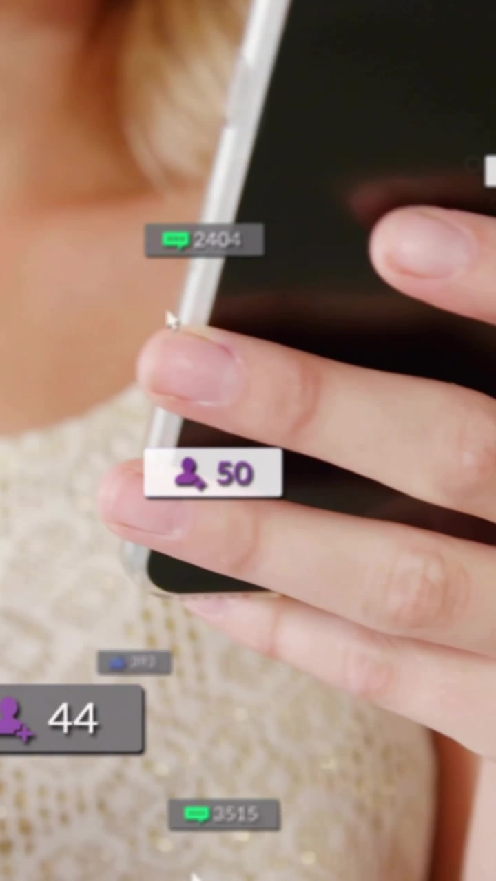 Video verticale: Creatrice che tiene in mano un telefono, avviando contatori fluttuanti e muovendo il telefono per tracciare i "mi piace".