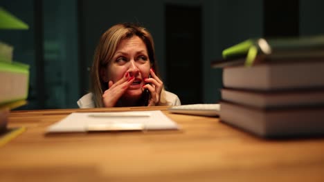 distressed woman crying while talking on phone at desk