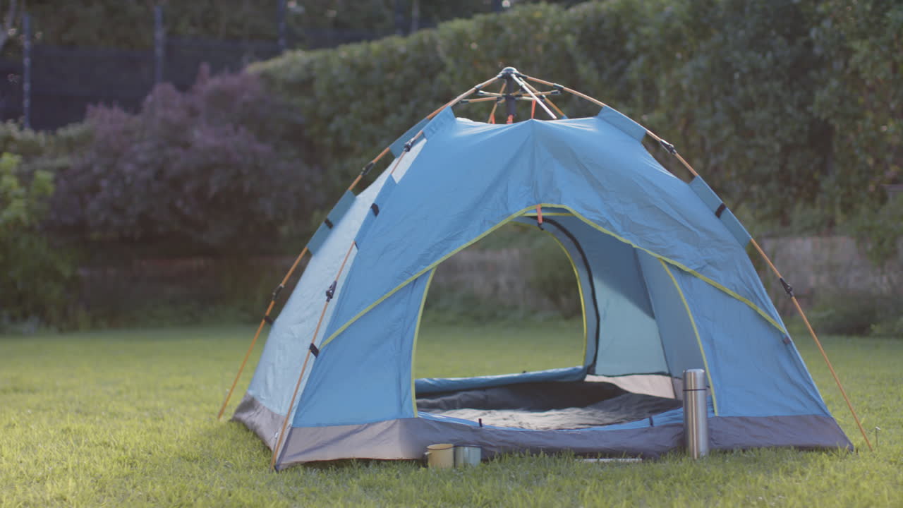 Blue camping tent set up on grass in backyard, ready for outdoor adventure