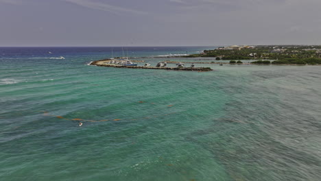 Puerto-Aventuras-Mexico-Aerial-v4-flyover-capturing-pristine-bay-water,-private-charters-docked-at-La-Bocana-Cove,-seafront-resort-hotels-and-vacation-homes---Shot-with-Mavic-3-Pro-Cine---July-2023