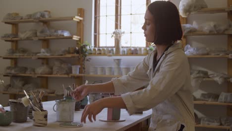 young female potter working in her studio