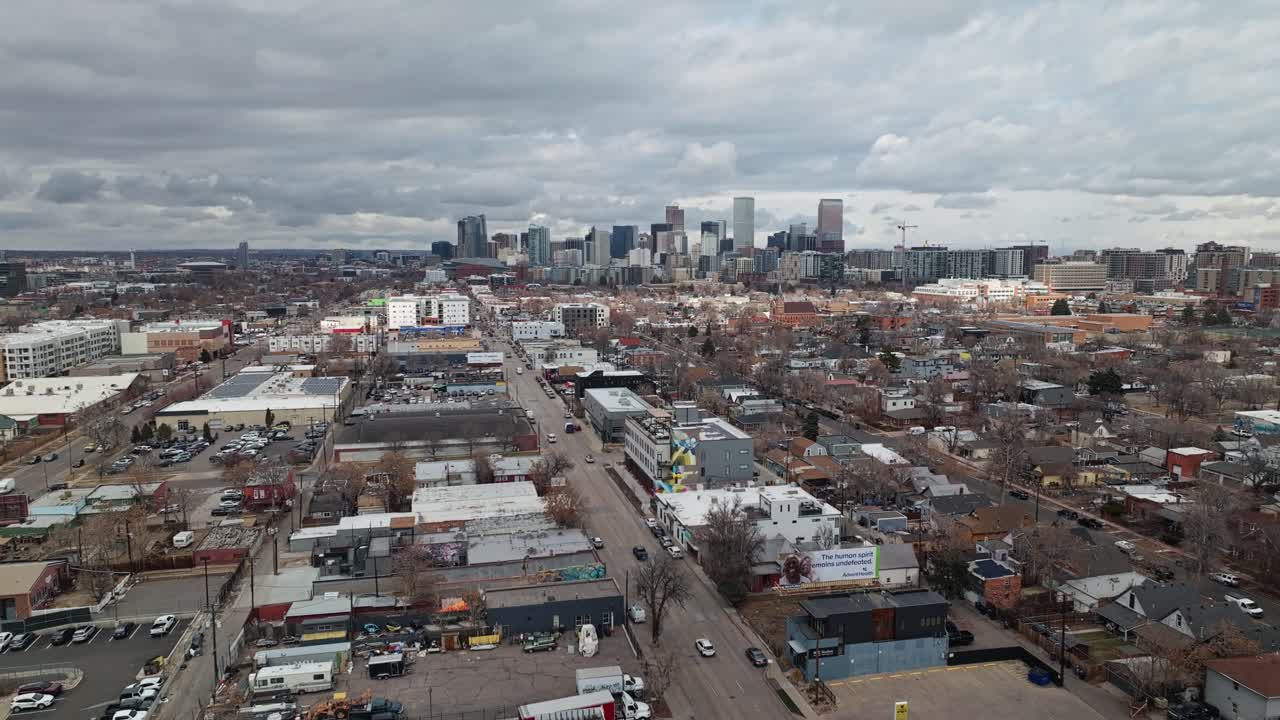 Ripresa aerea panoramica con allontanamento sopra un sobborgo industriale fuori Denver, Colorado, in una giornata nuvolosa