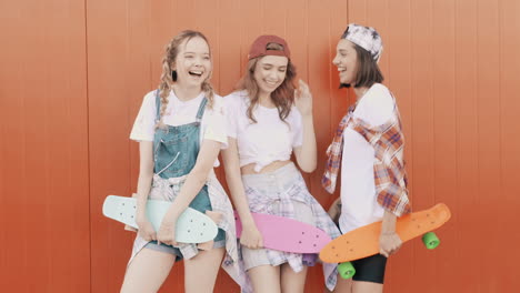 teenage girls laughing and skateboarding