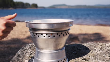 close up of girl putting on the lid of a trangia portable stove