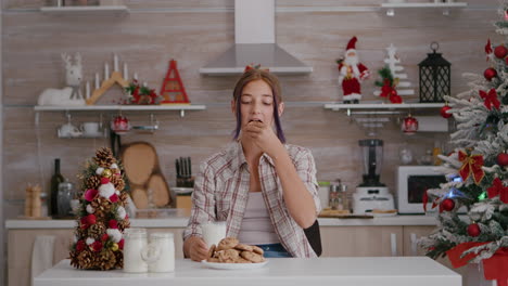 Portrait-of-children-looking-into-camera-while-sitting-at-table-in-xmas-decorated-kitchen