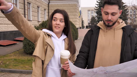 una pareja caucásica chequeando el mapa para obtener direcciones en la calle.