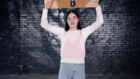 serious young environmental protester holding a cardboard with there is no planet b" inscription and protesting while looking at the camera"