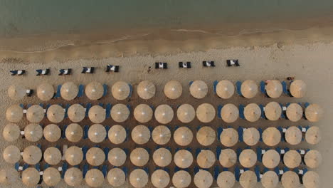 Flying-over-empty-sunbeds-at-seaside-in-the-morning