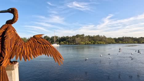 static bird sculpture with a dynamic lake backdrop