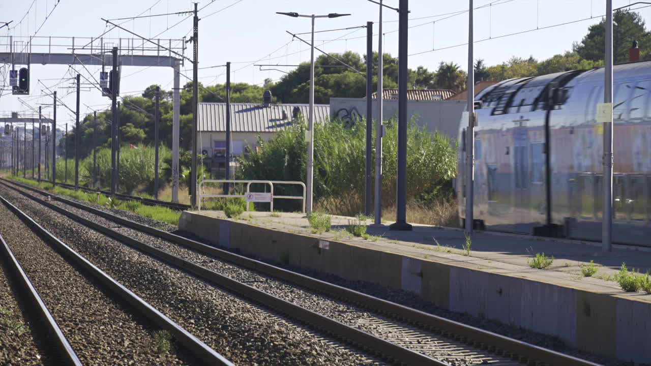 Antibes, France - June 7, 2025: Train moving on the rails, passing by a station