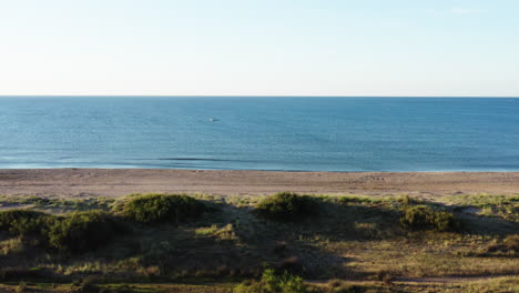 boat on the mediterranean sea beach with dunes and vegetation aerial