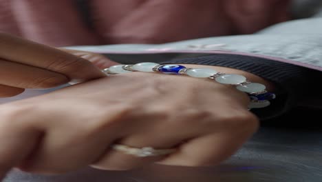 woman putting on a blue evil eye bead bracelet