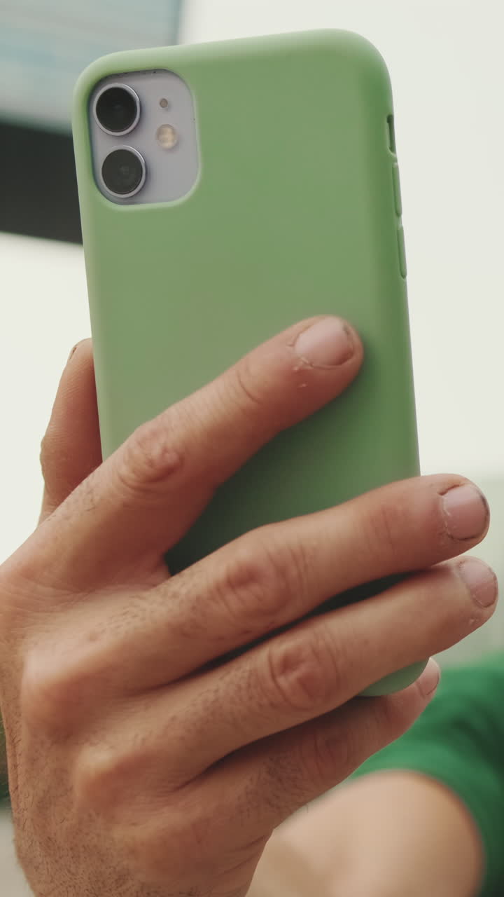 Primo piano di una mano che tiene in mano uno smartphone verde