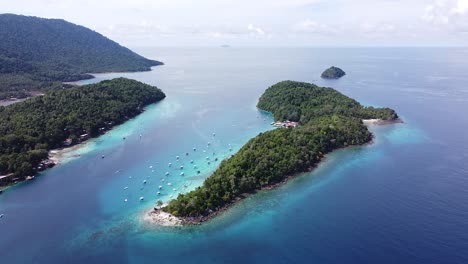 scenic aerial view of tropical island of pulau rubiah in pulau weh sabang indonesia with docked tour and fishing boats and turquoise ocean water