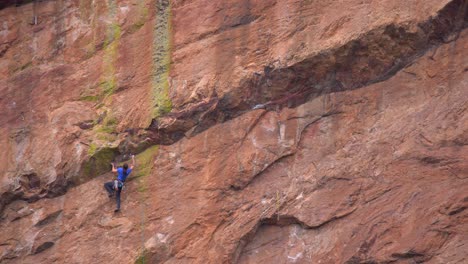 Mujer-Escalando-Una-Roca-Empinada-Usando-Equipo-De-Escalada