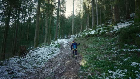 winter hike: caucasian woman leads the way through snowy forest