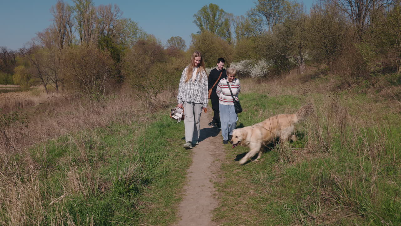 Family enjoying a walk in the park with a dog