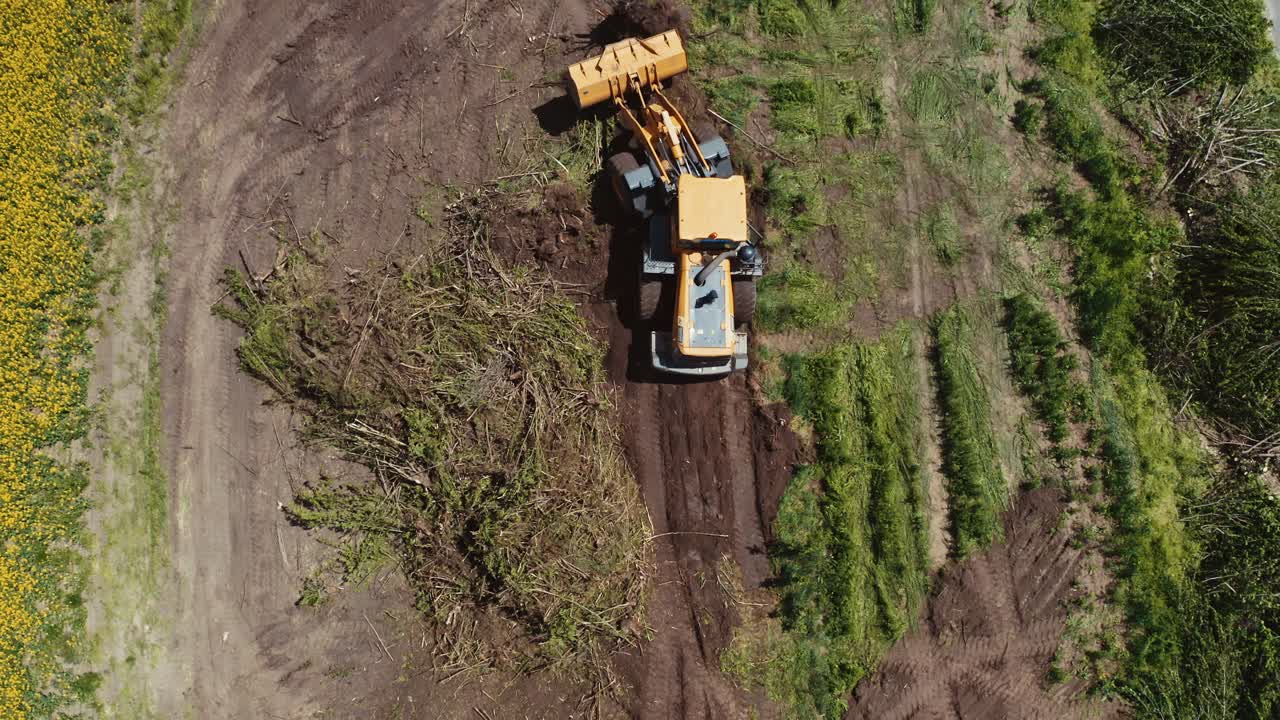 Bulldozer on countryside meadow. Top down view of bulldozer working on the field