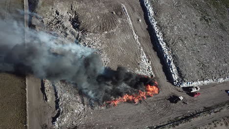 aerial view of smoke and fire from burning trash in landfill