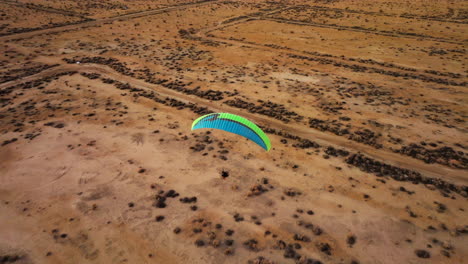 volando por encima de otro parapente motorizado sobre el paisaje del desierto de mojave