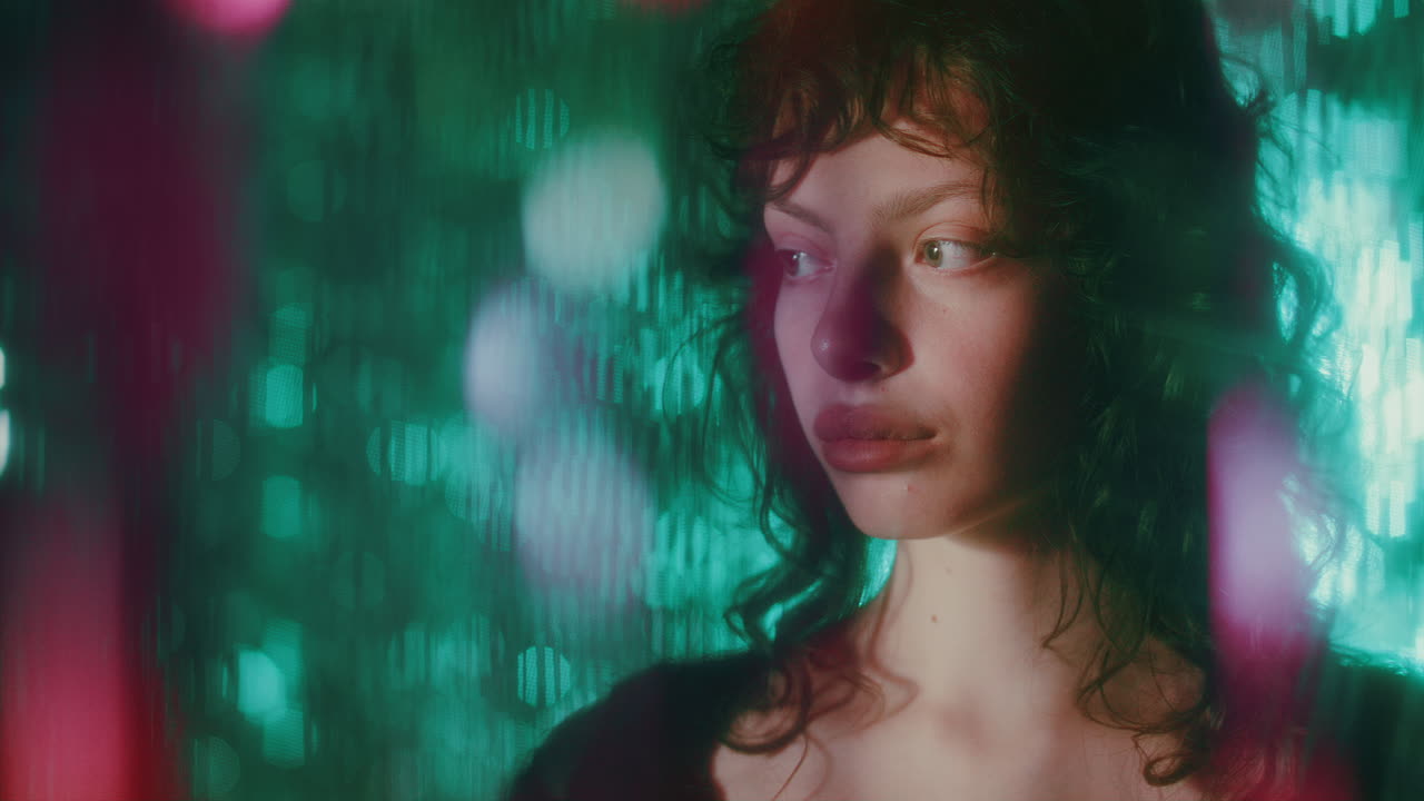 Portrait of Pretty Woman Standing in front Shiny Teal Backdrop