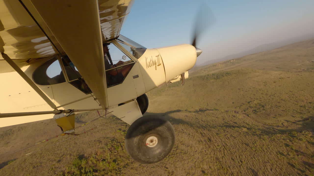 Avião leve sobre vista aérea de colina e vale com rio